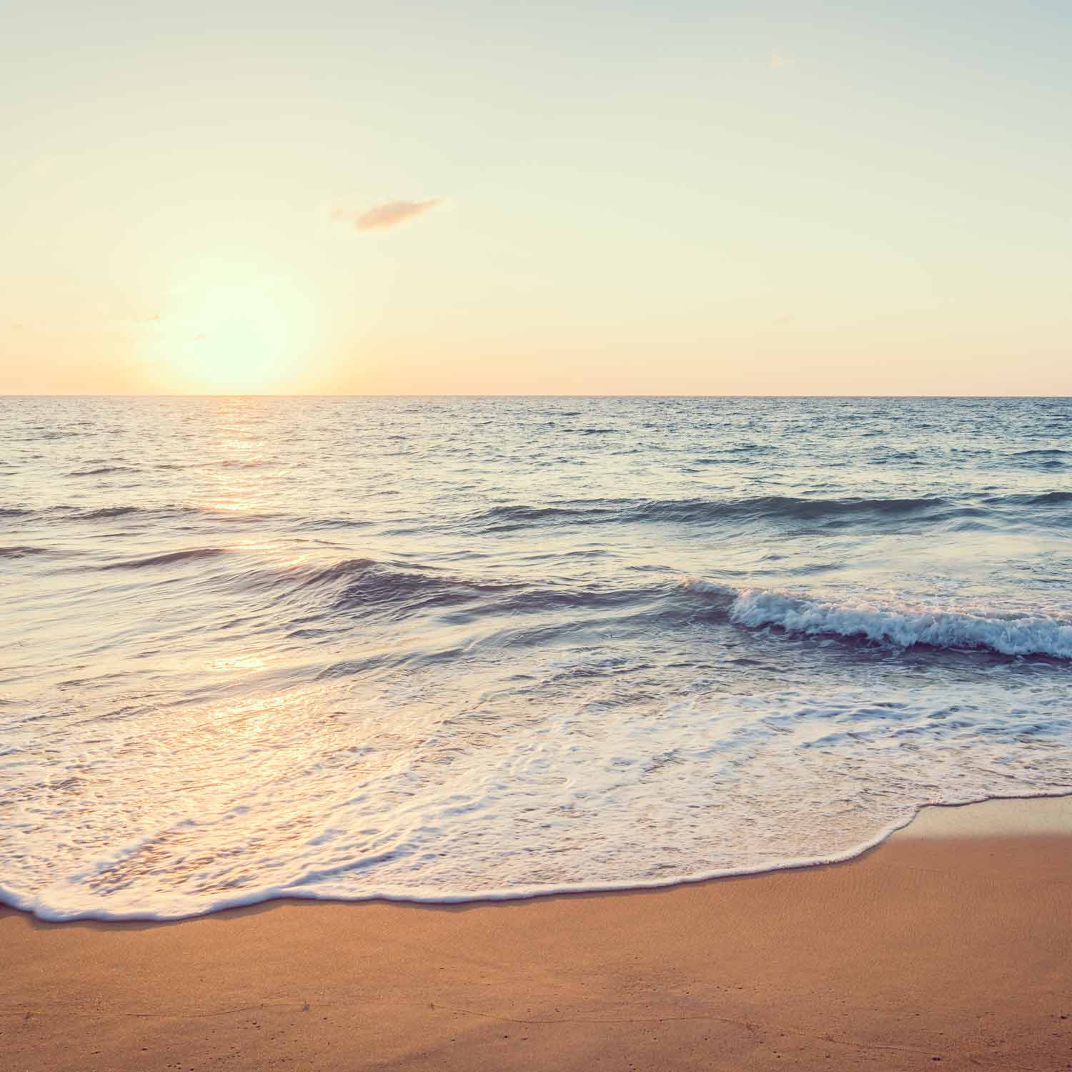 טפט ים גלים שוטפים את החוף ברכות בזמן שהשמש שוקעת